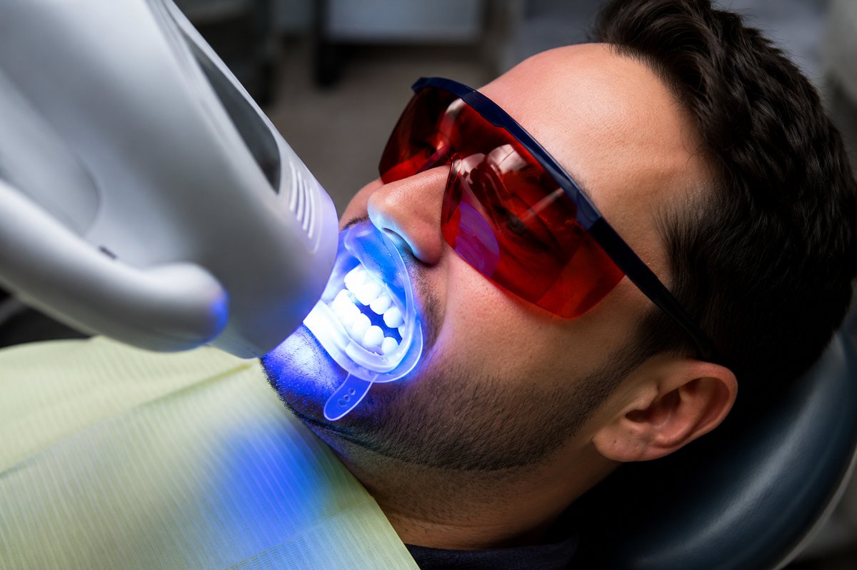 Patient undergoing Zoom whitening with protective eyewear at Cupo Dental Miami Beach